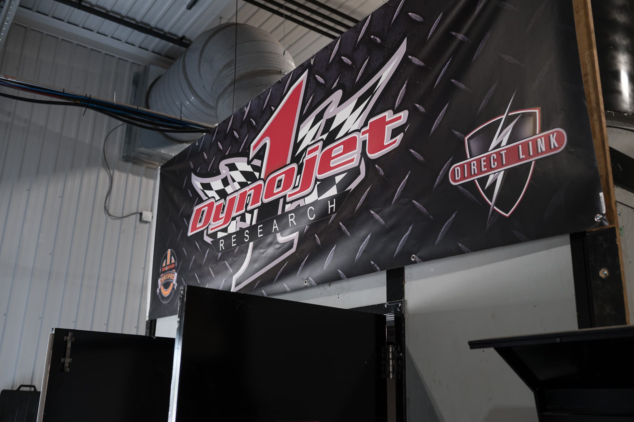 DynoJet Research direct-link banner hanging above the shop's dyno bay