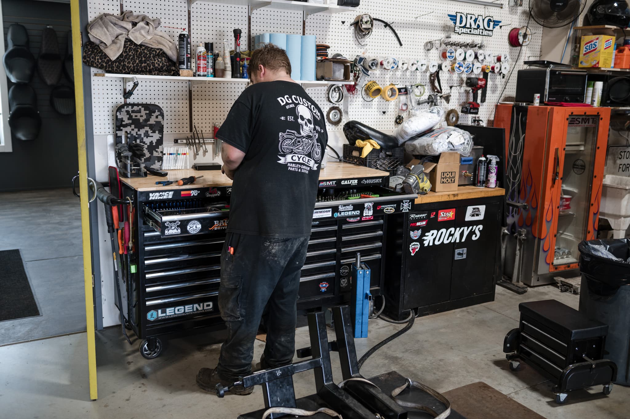 Technician unboxing and prepping a part for installation at DG Custom Cycle