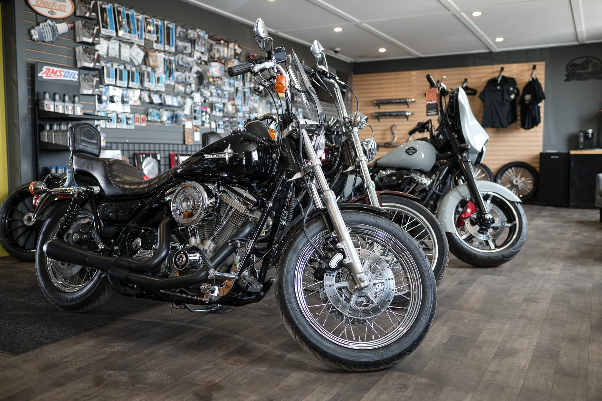 Lineup of Harley-Davidsons on the showroom floor next to the parts wall