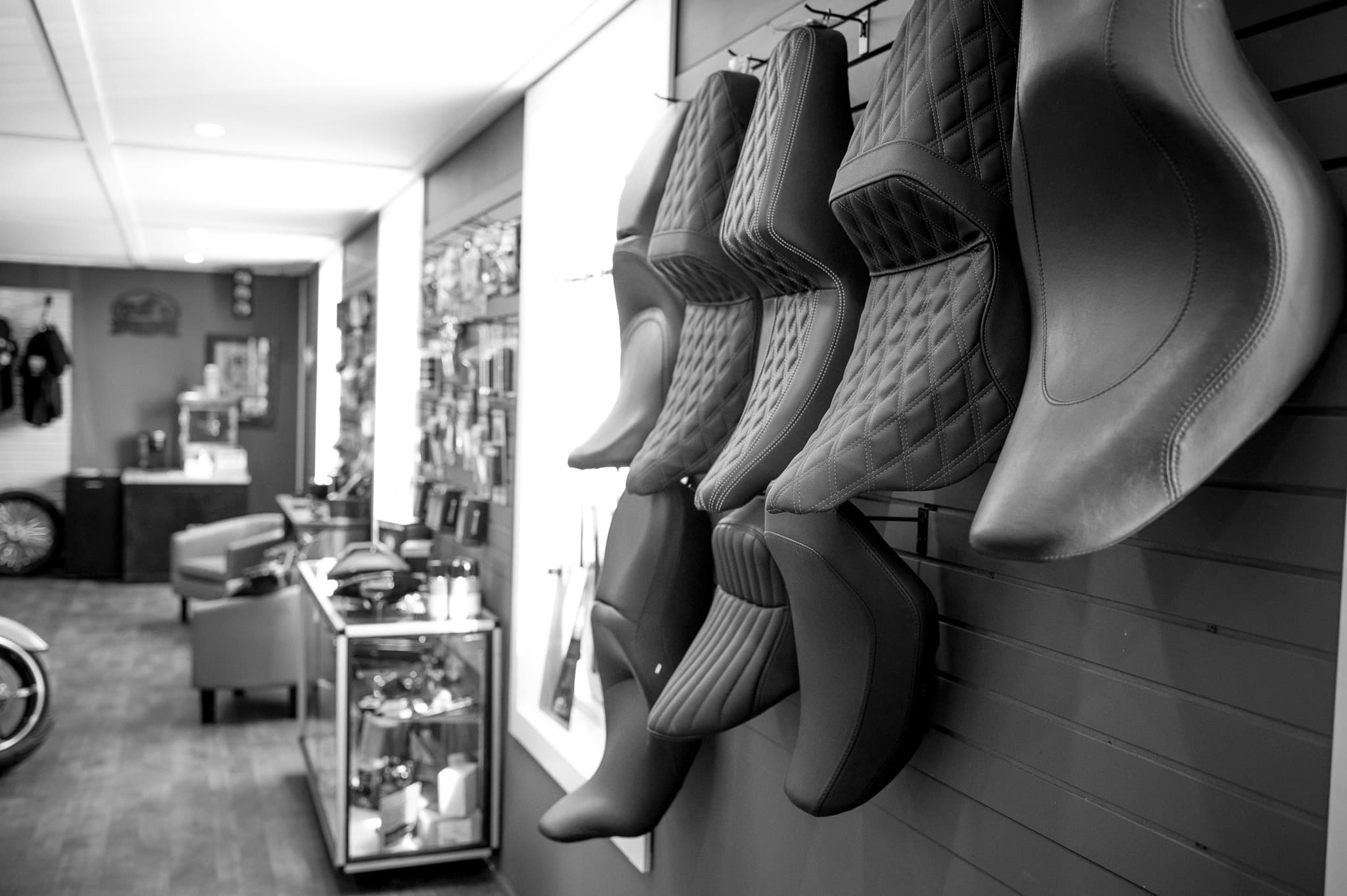 Motorcycle seats displayed on the showroom wall at DG Custom Cycle