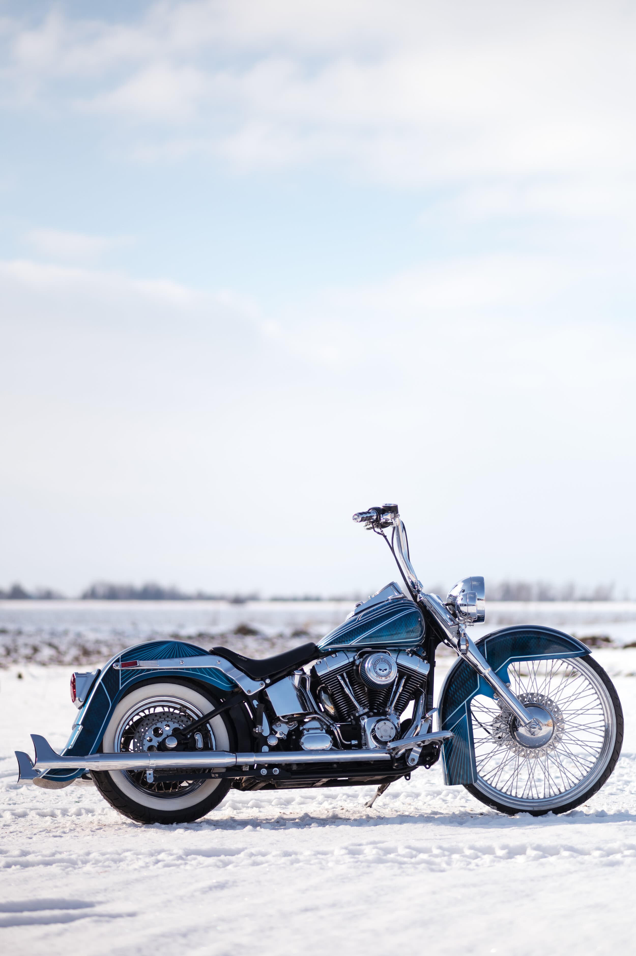 Blue Harley Softail parked on a snowy Ontario field, waiting for riding season