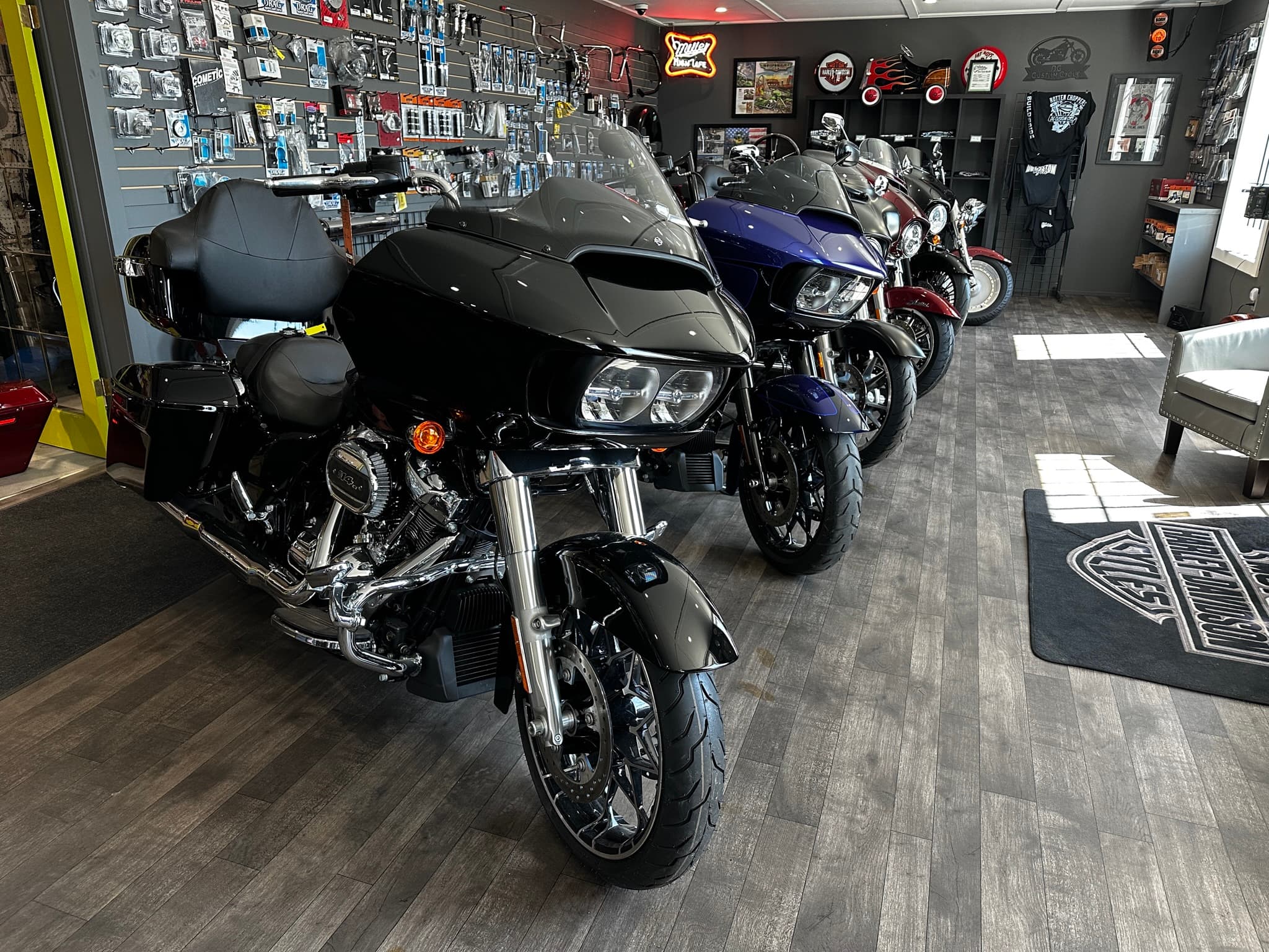 Harley-Davidson baggers lined up in the DG Custom Cycle showroom, parts wall and shop floor in view